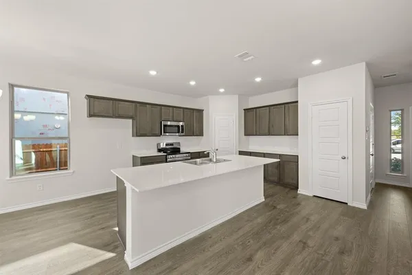 a kitchen with a stove a sink and a microwave