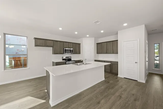 a kitchen with a stove a sink and a microwave