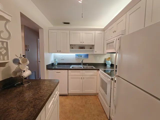 a kitchen with granite countertop a sink stove and cabinets