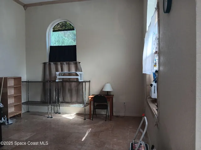 a view of a hallway with workspace and a window