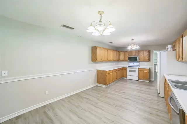 a large kitchen with a wooden floor and stainless steel appliances