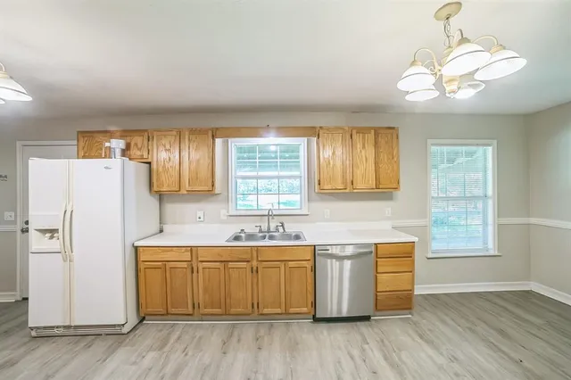 a kitchen with a sink a refrigerator and window