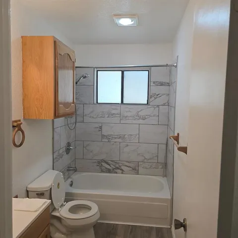 a bathroom with a bathtub shower sink mirror and toilet