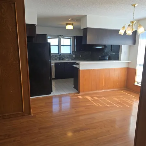 a view of a kitchen with a sink and a refrigerator
