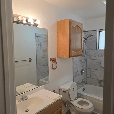 a view of a kitchen with wooden floor and a refrigerator