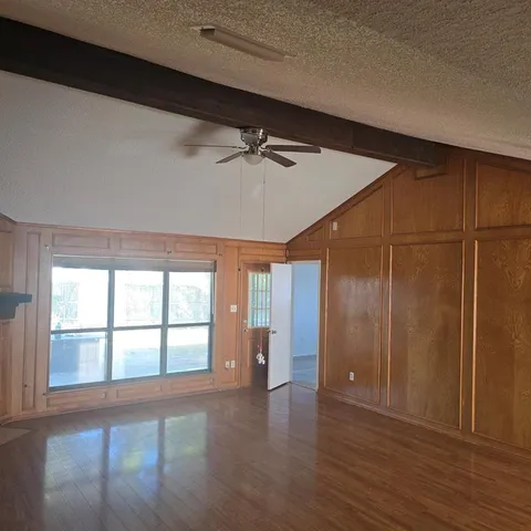 a view of an empty room with a fireplace and a window