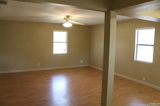 an empty room with windows and cabinet