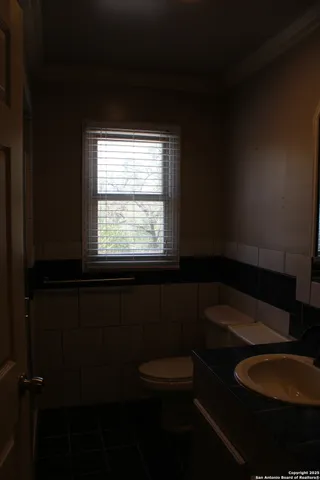 a bathroom with a toilet a sink and a window