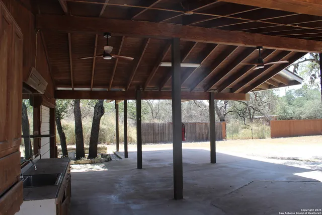a view of porch with a table and chairs under an umbrella