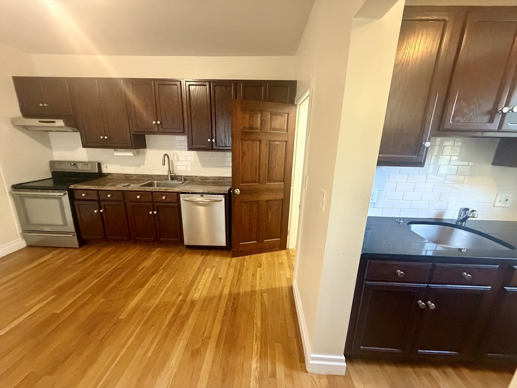 19 Banks Street, Unit 1 Somerville, MA 02144 - Photo 1 of 16 a kitchen with wooden cabinets and a sink