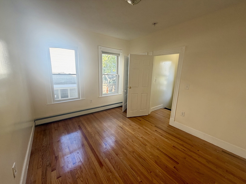 19 Banks Street, Unit 1 Somerville, MA 02144 - Photo 15 of 16 a view of an empty room with wooden floor and window