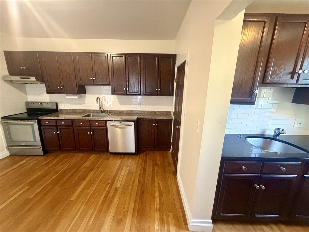 19 Banks Street, Unit 1 Somerville, MA 02144 - Photo 3 of 16 a kitchen with wooden cabinets and sink