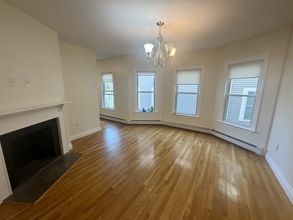 19 Banks Street, Unit 1 Somerville, MA 02144 - Photo 4 of 16 wooden floor in an empty room with a fireplace