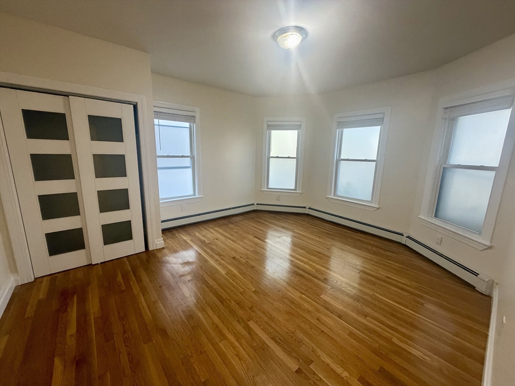 19 Banks Street, Unit 1 Somerville, MA 02144 - Photo 7 of 16 a view of empty room with wooden floor and fan