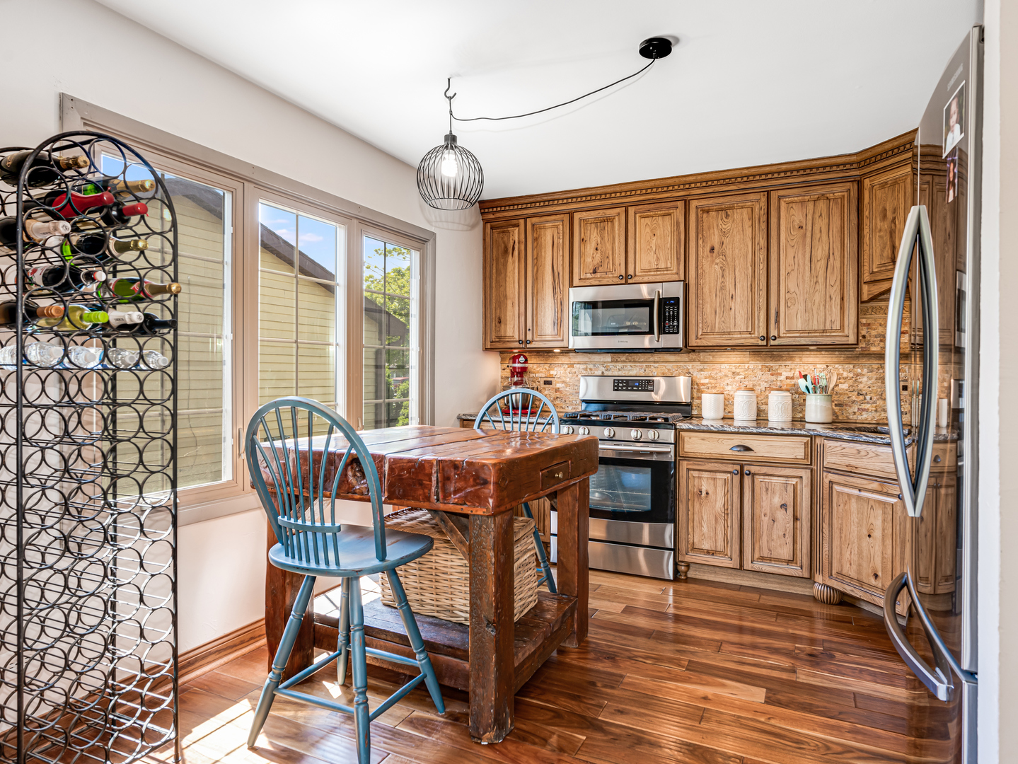 302 Delaware Drive Bolingbrook, IL 60440 - Photo 8 of 21 a kitchen with stainless steel appliances granite countertop a stove top oven a dining table and chairs with wooden floor