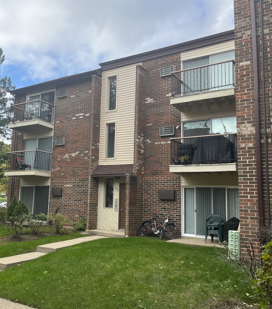 550 Pleasant Run Drive Wheeling, IL 60090 - Photo 1 of 7 front view of a brick house with a yard