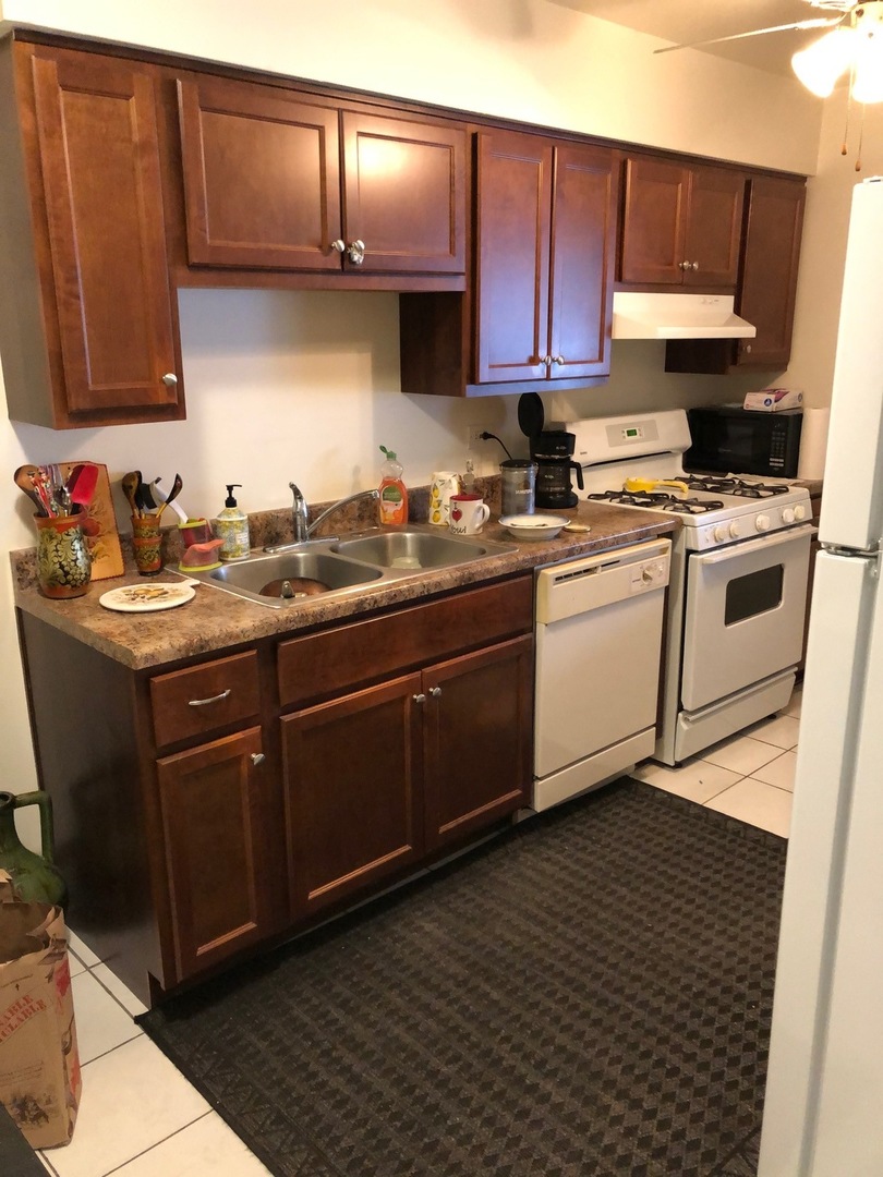 550 Pleasant Run Drive Wheeling, IL 60090 - Photo 2 of 7 a kitchen with a sink a stove and cabinets