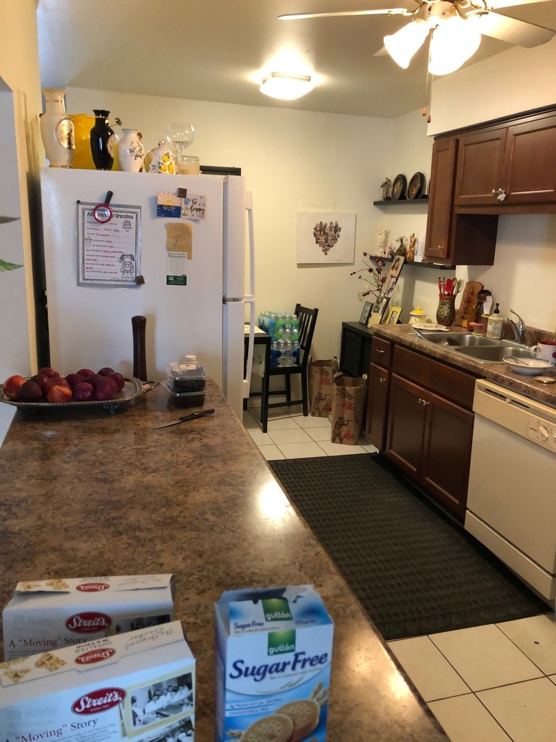 550 Pleasant Run Drive Wheeling, IL 60090 - Photo 3 of 7 a kitchen with kitchen island granite countertop a sink cabinets and appliances