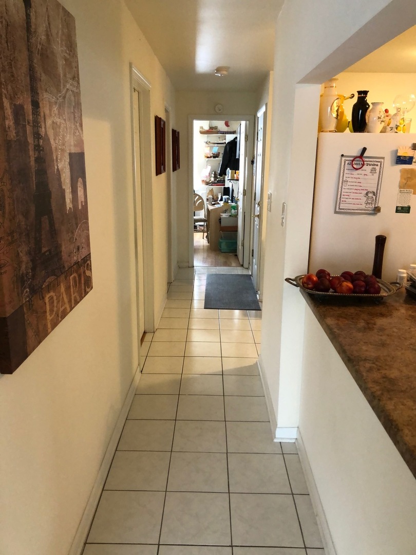 550 Pleasant Run Drive Wheeling, IL 60090 - Photo 5 of 7 a hallway with a view of kitchen with refrigerator and window
