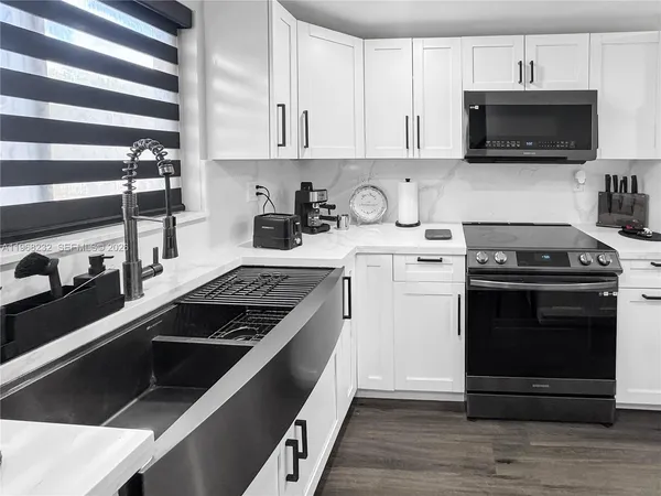 a kitchen with stainless steel appliances granite countertop a stove and a microwave