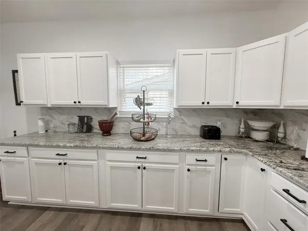 a kitchen with stainless steel appliances granite countertop white cabinets and sink