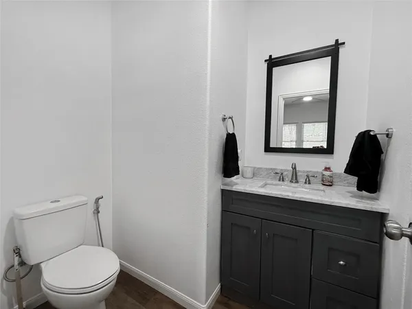a bathroom with a toilet a sink a vanity and mirror