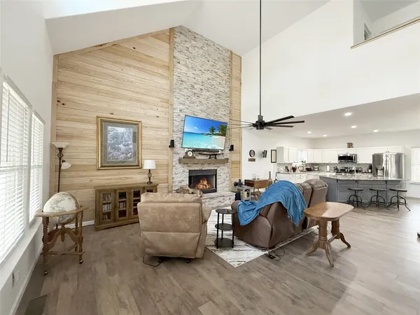 a living room with furniture a fireplace and kitchen view