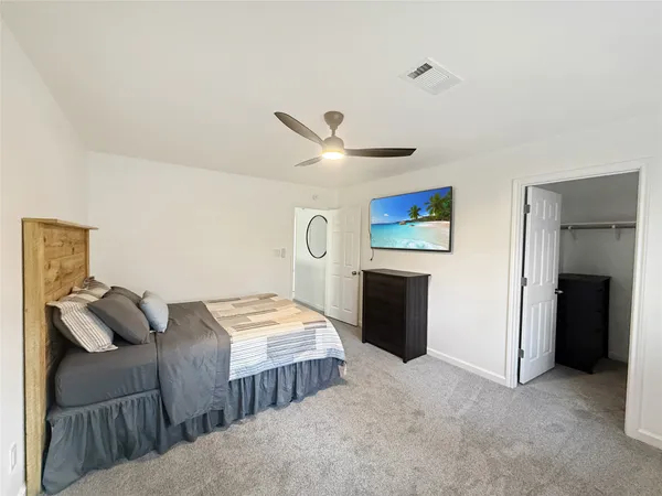 a bedroom with a bed and a ceiling fan