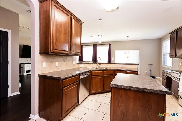 a kitchen with stainless steel appliances granite countertop a stove and a refrigerator