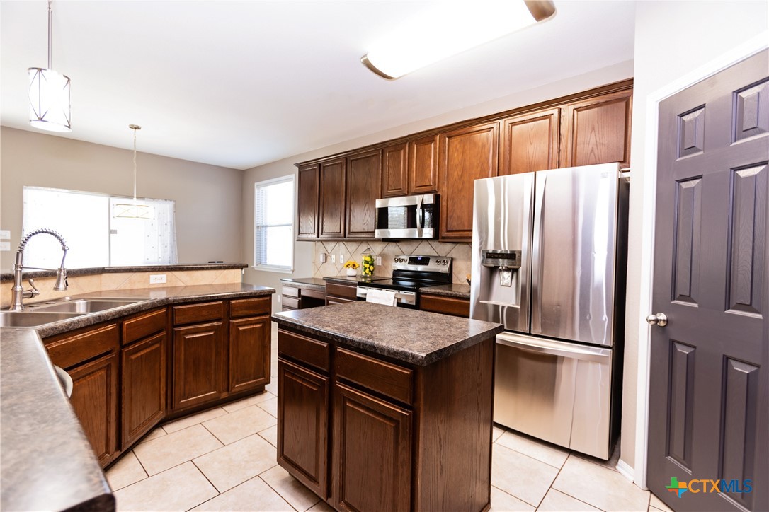 612 Pumpkin Drive Temple, TX 76502 - Photo 12 of 33 a kitchen with stainless steel appliances granite countertop a refrigerator stove microwave and sink