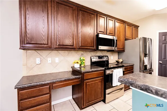 a kitchen with stainless steel appliances granite countertop a sink stove and cabinets