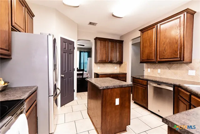 a kitchen with stainless steel appliances granite countertop a refrigerator stove microwave and sink