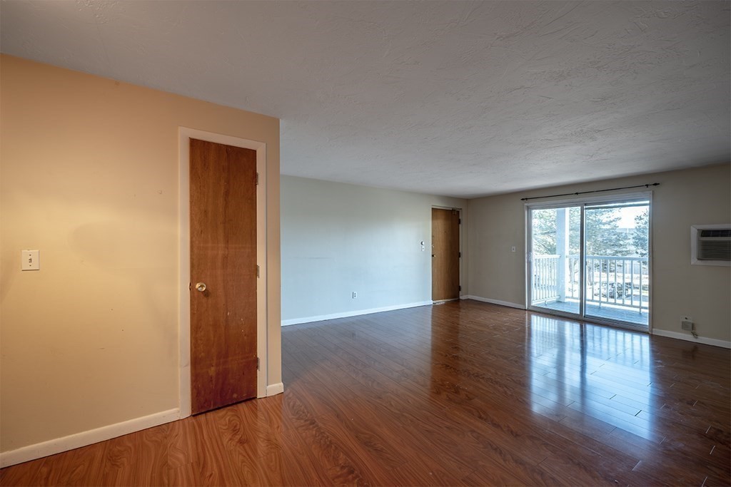 57 Will Drive, Unit 170 Canton, MA 02021 - Photo 3 of 15 a view of an empty room with wooden floor and a window