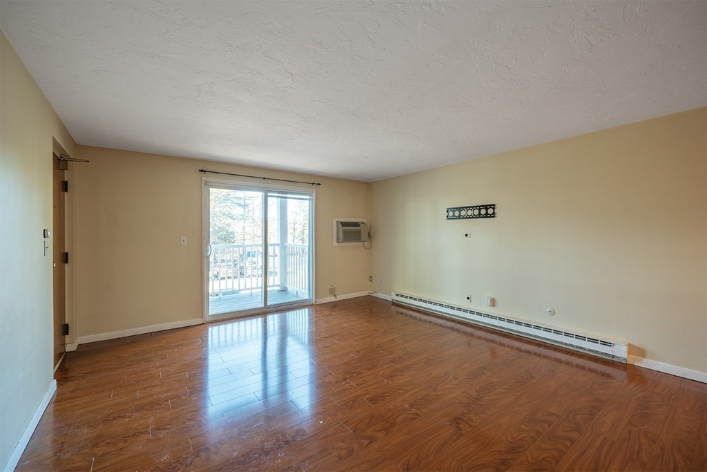 57 Will Drive, Unit 170 Canton, MA 02021 - Photo 4 of 15 an empty room with wooden floor and windows
