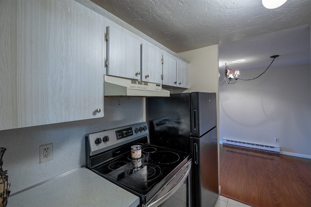 57 Will Drive, Unit 170 Canton, MA 02021 - Photo 5 of 15 a kitchen with a stove and a refrigerator