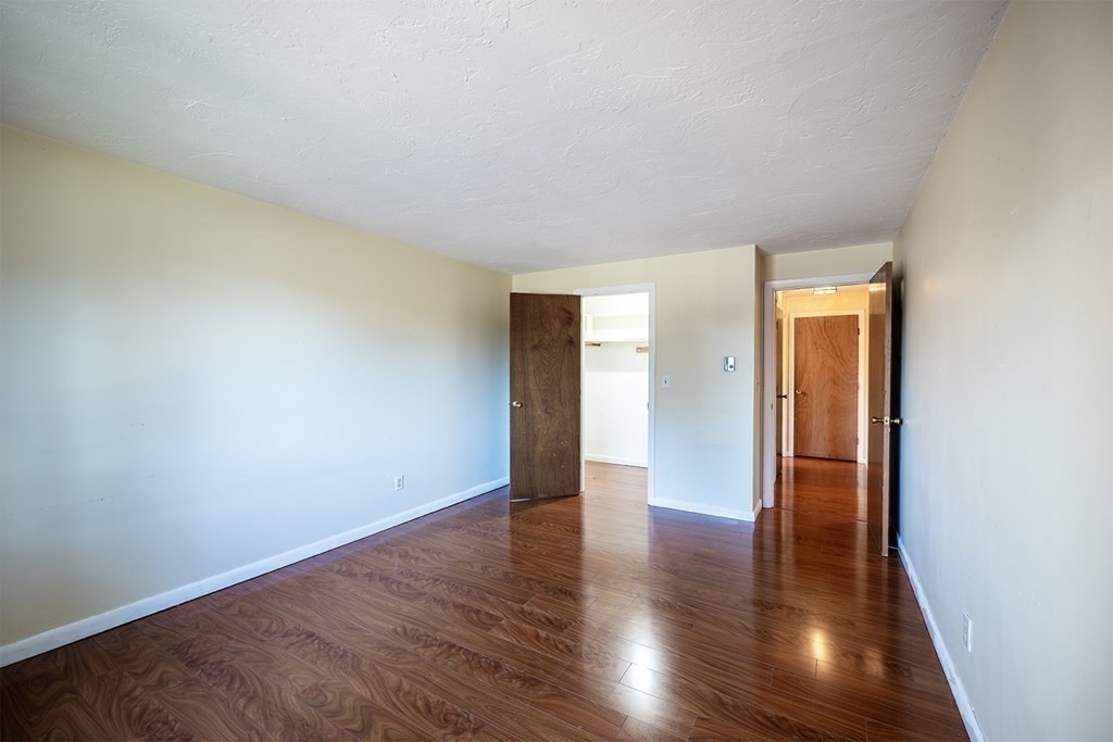 57 Will Drive, Unit 170 Canton, MA 02021 - Photo 7 of 15 a view of an empty room with wooden floor and closet