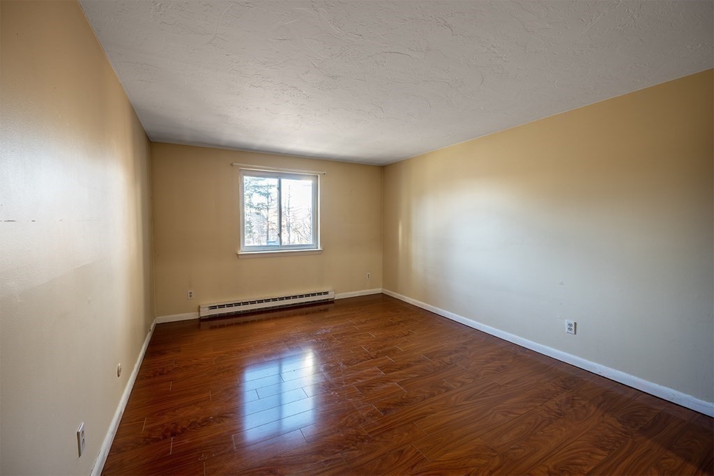 57 Will Drive, Unit 170 Canton, MA 02021 - Photo 8 of 15 an empty room with wooden floor and windows