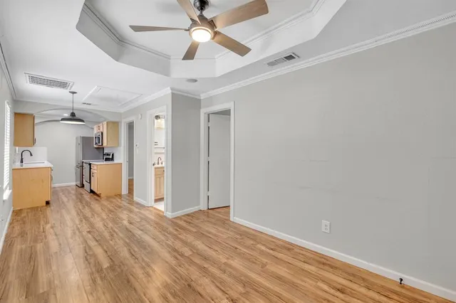 a view of a big room with wooden floor and a ceiling fan