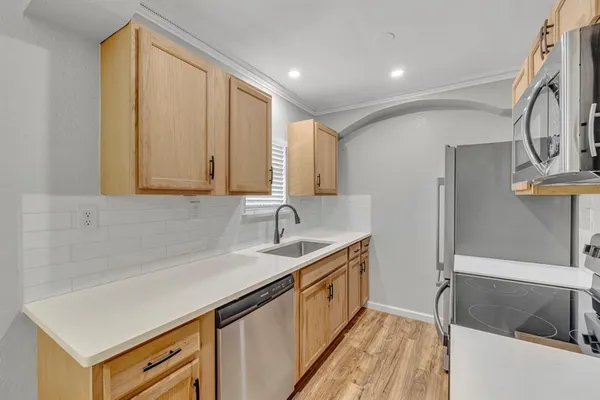 a kitchen with a sink cabinets and a wooden floor