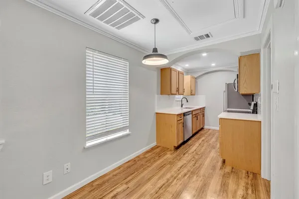 a kitchen that has a lot of cabinets in it and wooden floors