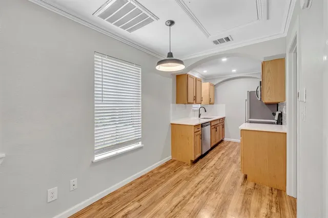 a kitchen that has a lot of cabinets in it and wooden floors