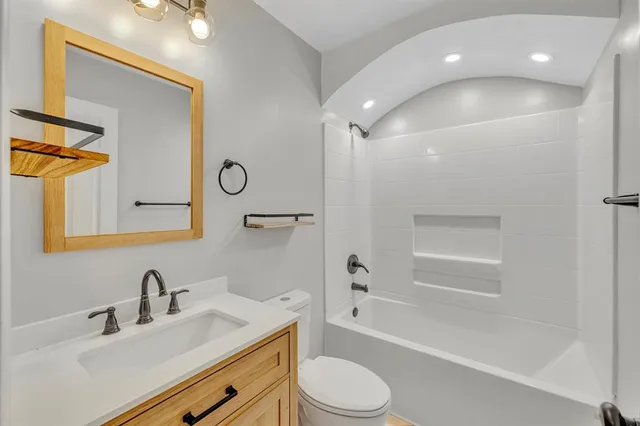 a bathroom with a granite countertop sink toilet and shower