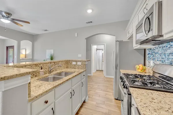 a spacious bathroom with a granite countertop sink and a mirror