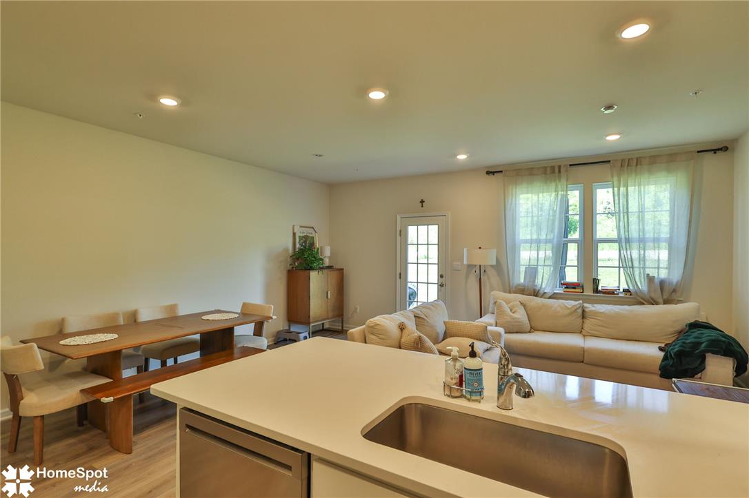 1224 Martin Road Breinigsville, PA 18031 - Photo 14 of 26 An open concept living area boasts a modern kitchen island, dining space, and inviting sitting area, all naturally illuminated.