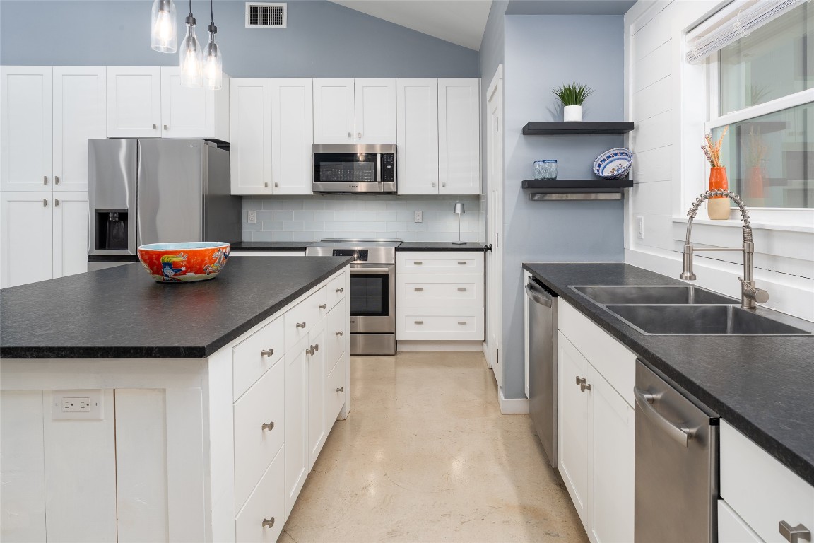 33 Deer Ridge Road Wimberley, TX 78676 - Photo 14 of 40 a kitchen with stainless steel appliances granite countertop a sink a stove and a refrigerator