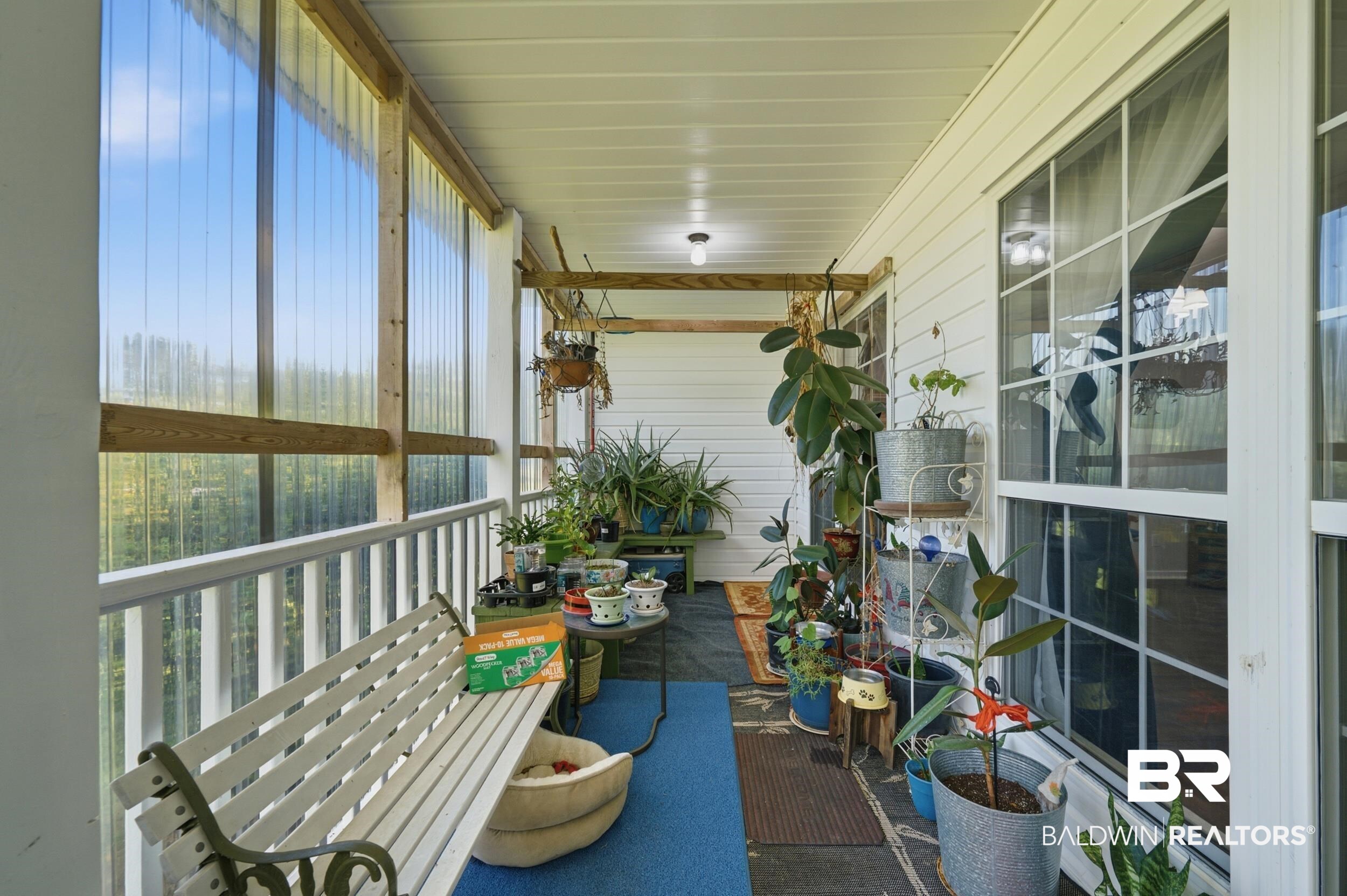 15855 Calvin Richerson Road Bay Minette, AL 36507 - Photo 12 of 83 Enclosed porch featuring an overhead light fixture, white baluster railing, corrugated translucent wall panels, and multi-pane windows