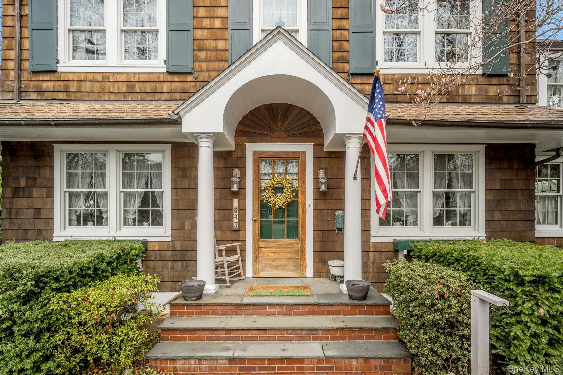 343 Rye Beach Avenue Rye, NY 10580 - Photo 2 of 35 a view of a brick house with plants and large windows