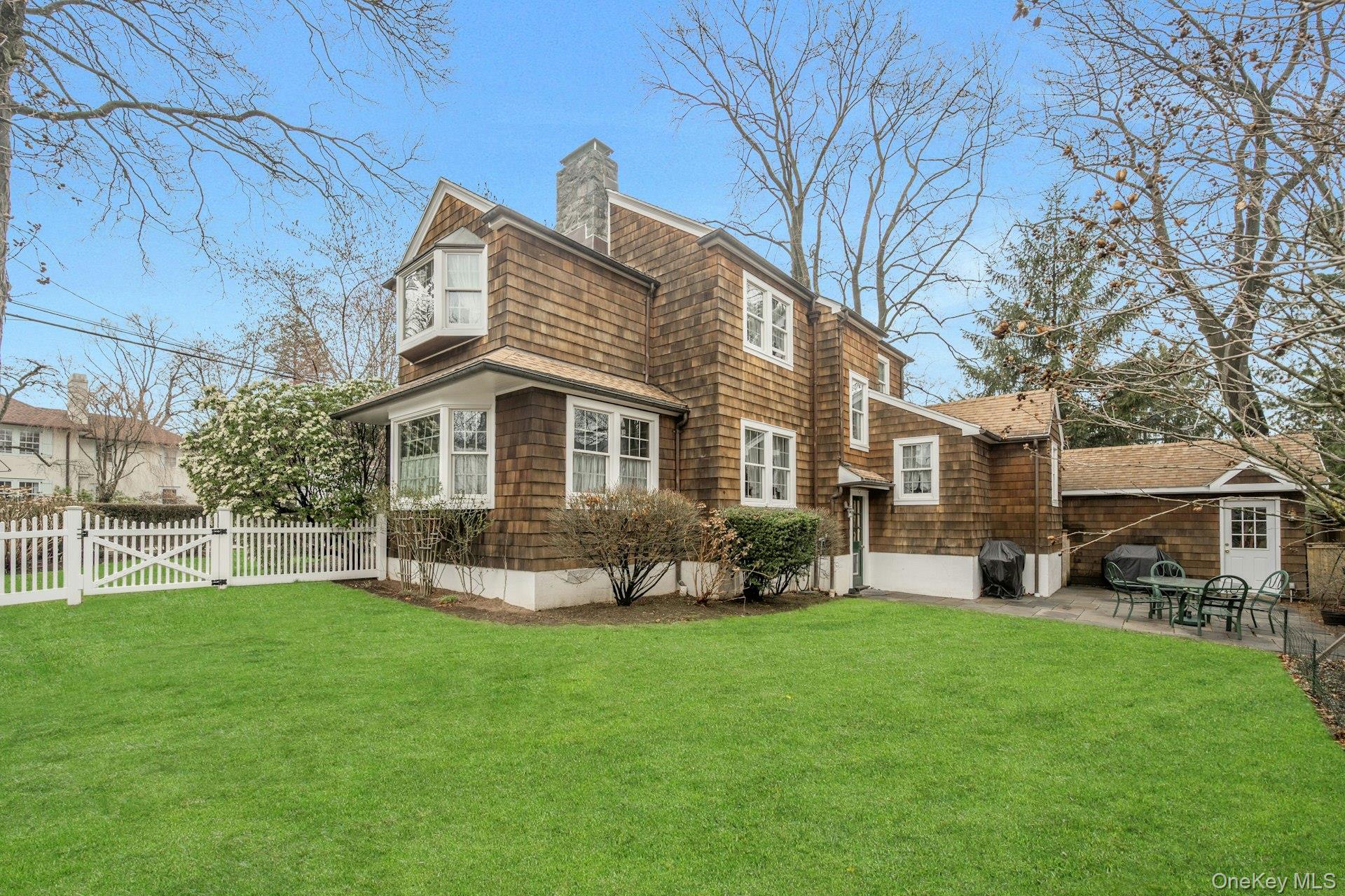 343 Rye Beach Avenue Rye, NY 10580 - Photo 29 of 35 a front view of a house with a garden and trees