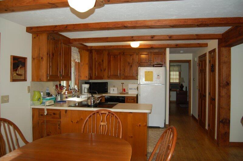 27 Pine View Drive Brewster, MA 02631 - Photo 8 of 17 a kitchen with stainless steel appliances granite countertop a refrigerator a sink a stove and white cabinets with wooden floor
