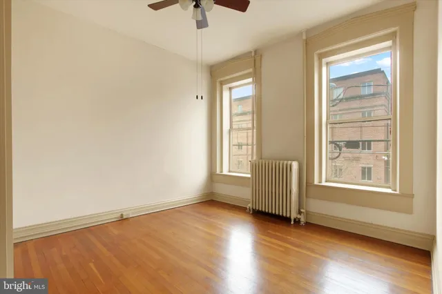 a view of an empty room with wooden floor